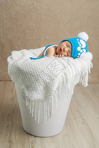 蓝色帽子睡觉的美丽的新生婴儿图片
