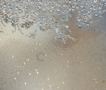 窗子上有银霜的多彩背景窗子上的冷冻水创造了银色背景图片