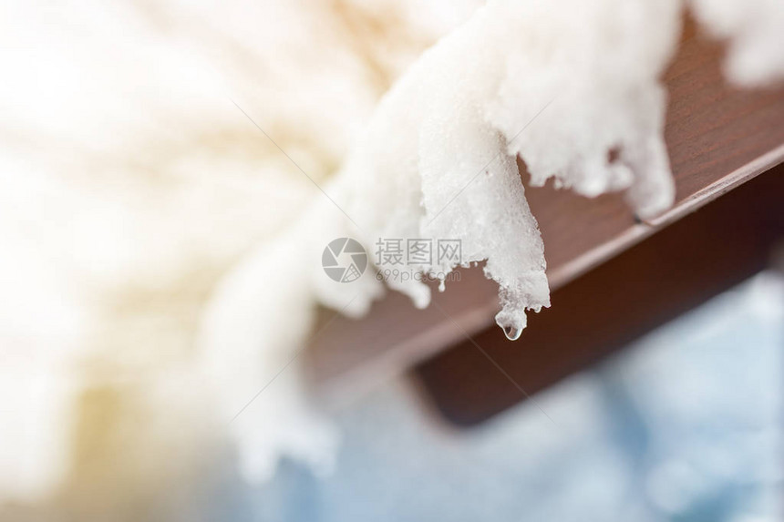 屋顶上融化的雪冰柱的特写镜头落水滴春天的开始满足冷热概念新鲜的图片