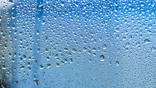 窗户上的雨滴抽象的背景蓝色调图片
