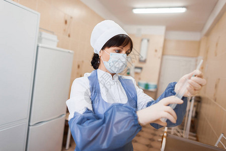 一名身戴面具身着医疗服的女医生正准备向病人介绍流感疫苗图片