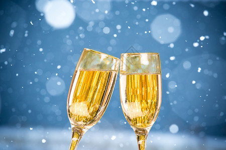 在蓝色背景上用两个香槟杯飘落的雪花图片