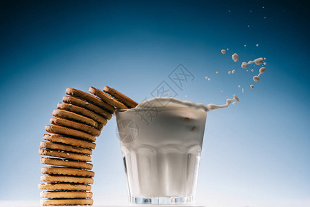 一大堆饼干洒在玻璃牛奶里图片