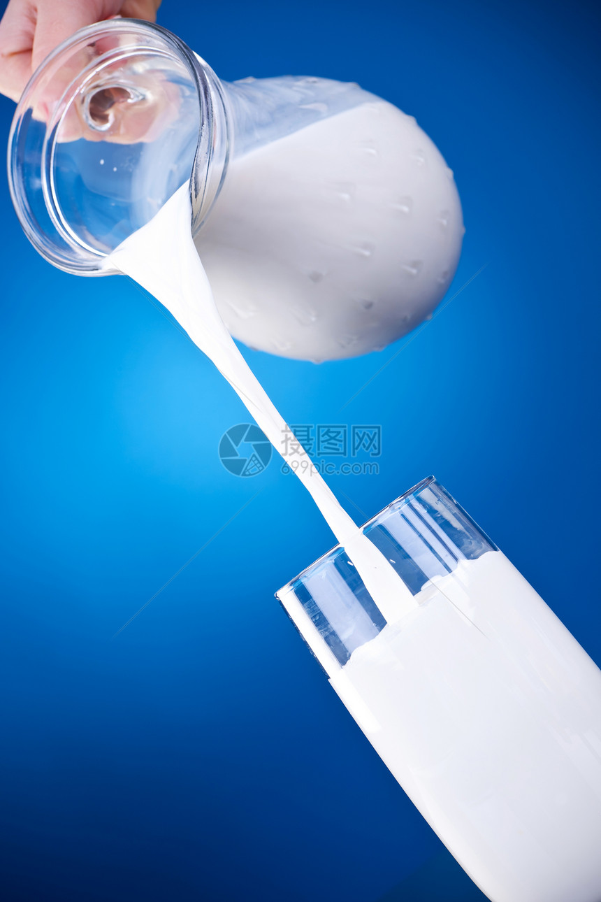 将牛奶从一个罐子倒入蓝色图片
