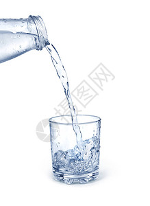 蓝色的水从瓶子里倒进被隔绝的玻璃杯里图片