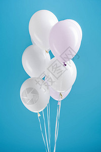 五颜六色的蓝色背景上的白色装饰气球背景图片
