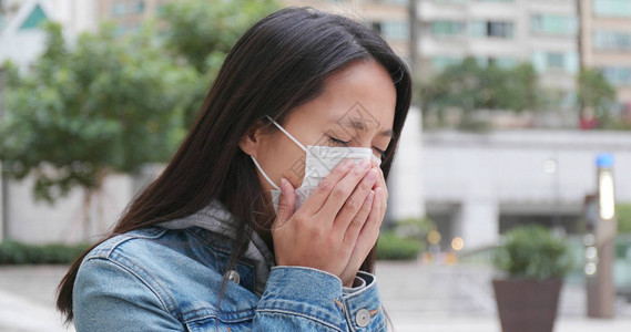 在户外戴口罩咳嗽的女人图片