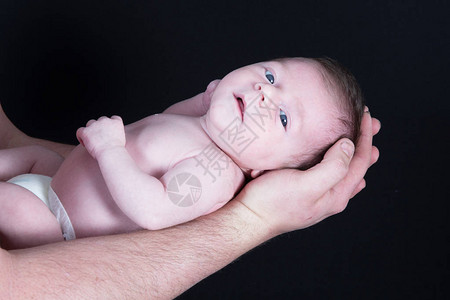 父亲躺在手臂上的新生婴图片