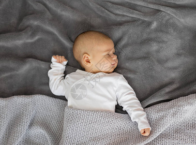 睡在灰色毯子上的婴儿图片