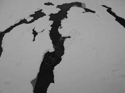 山上冬季河流的冰层裂缝图片