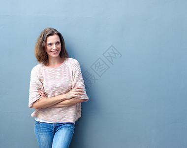 一个微笑着的中年成妇女带着双臂站在十图片