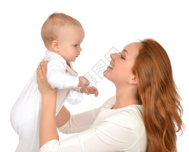 年轻的母亲抱着和拥抱在她的怀里的婴儿女孩在白色图片
