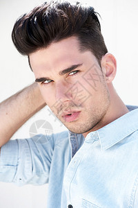 一个有吸引力的男时装模特的写肖像与头发的手图片