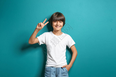 穿着T恤微笑的小男孩在彩色背景上表现图片