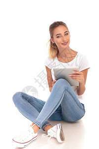 坐在白种背景的平板电脑上看书的年轻图片