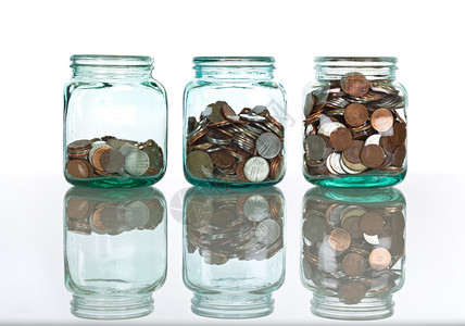 中级经济师玻璃罐反射表面有硬币的玻璃罐孤背景