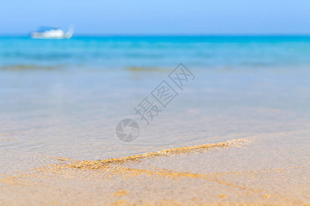 桑迪海滩上的蓝色海洋的软波背景图片