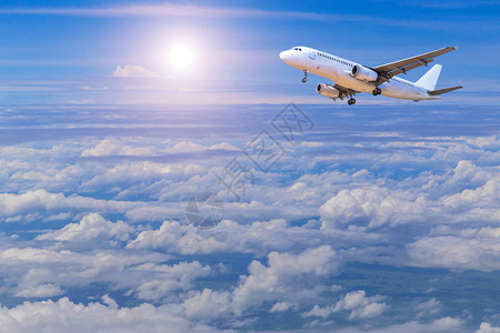 白色商业飞机向天空高空飞越白云上空阳图片