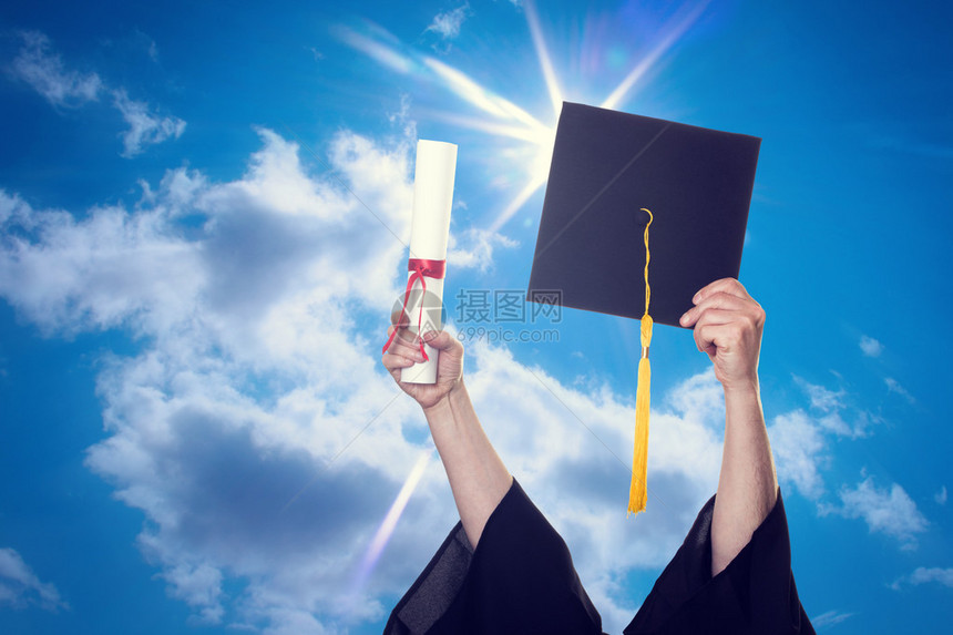 毕业帽和文凭扔在蓝天上图片