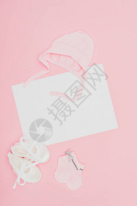 空板的顶部视图婴儿衣服被粉红色隔开背景图片
