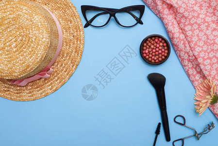 女用品与化妆品的俯视图夏季配饰与化妆品拼贴蓝色背景图片