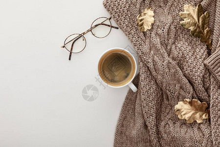 白色背景上的毛衣眼镜咖啡和金叶图片