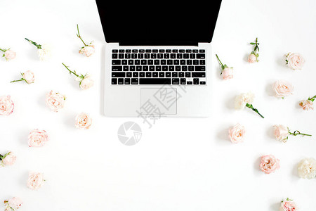 笔记本电脑和花朵图案由白底的蜜蜂玫瑰花芽制成图片