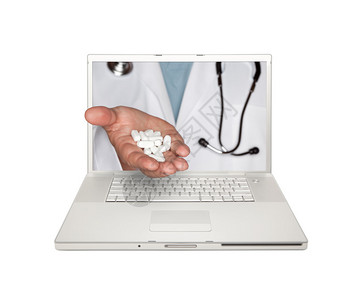 医生通过笔记本电脑屏幕把药片从白色背背景图片