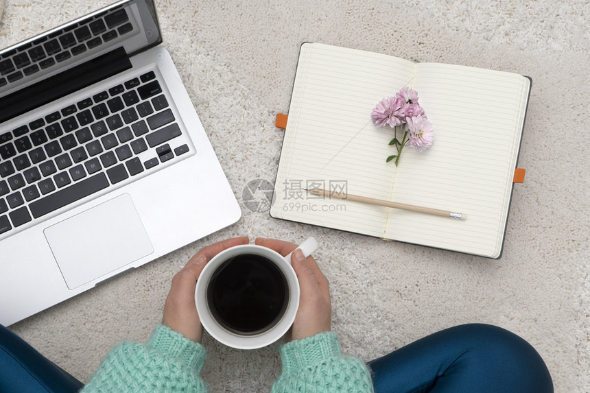 笔记本笔记本和一杯咖啡放在女孩手中图片