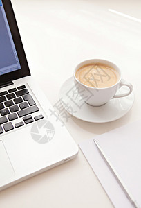 用笔记本电脑一杯咖啡一张空白纸和一支笔背景图片