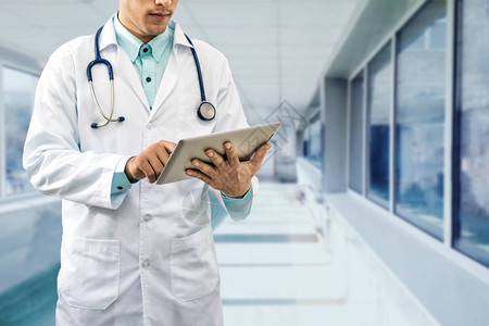 在医院或办公室背景下研究平板电脑的男医生医疗数据分析和医疗保图片