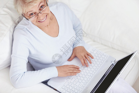 一位有吸引力的中年妇女在白色沙发上架图片