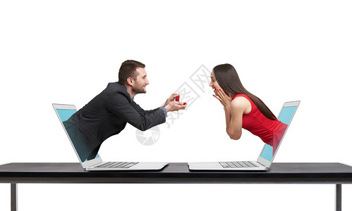 一对虚拟情侣从电脑里出来令人惊讶的快乐女人看着礼物幸福男人看着她孤立图片