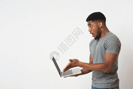 惊吓的年轻非裔美国人使用笔记本电脑图片
