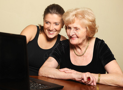 一张使用计算机的一位高级女士及背景图片