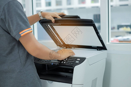 将文件纸放入打印机扫描仪或办公室激光复印机的自动处背景图片