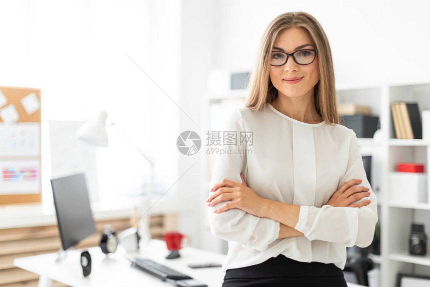 身穿白上衣和黑裙子的美丽金发美女孩正在办公室工作图片