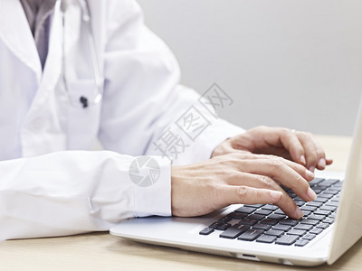 医生在笔记本电脑上打字的手图片