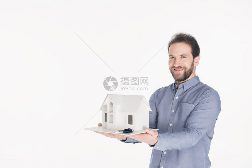手握着房屋模型和钥匙的笑脸胡子男肖像在图片