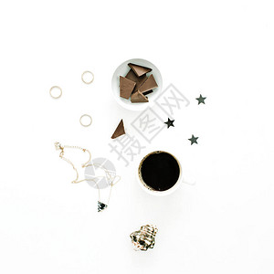 以咖啡杯巧克力贝壳星项链和圆环为白背景的小型创意组合图片