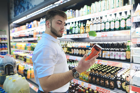 一个留着胡子的帅哥在超市里挑选啤酒买家在超市买酒一个男人图片