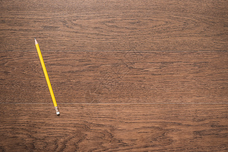 木制背景上的黄色铅笔顶视图图片