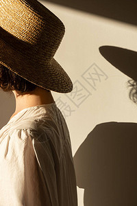 穿着草帽和白色裙子日光浴的年轻美女图片