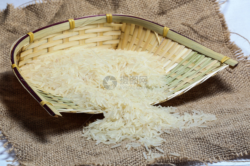黄麻袋上的白色长粒米和竹锅金属勺图片
