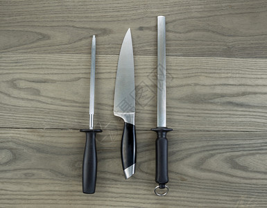 一张大厨房刀和两台白灰木上背景图片