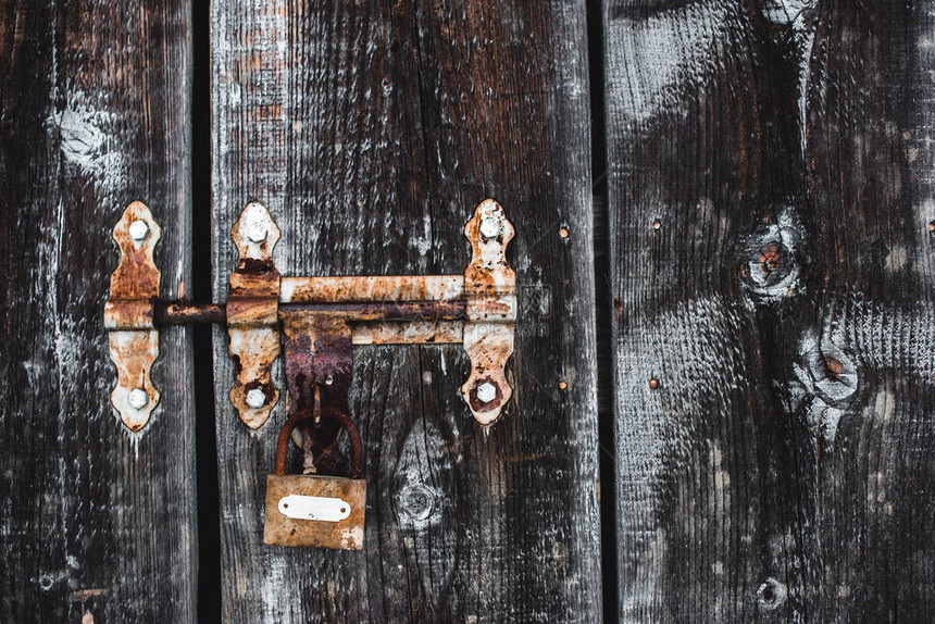 木门上的旧风化生锈锁图片