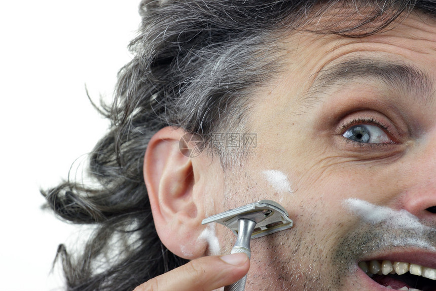 男人用老式剃须刀刮脸颊图片