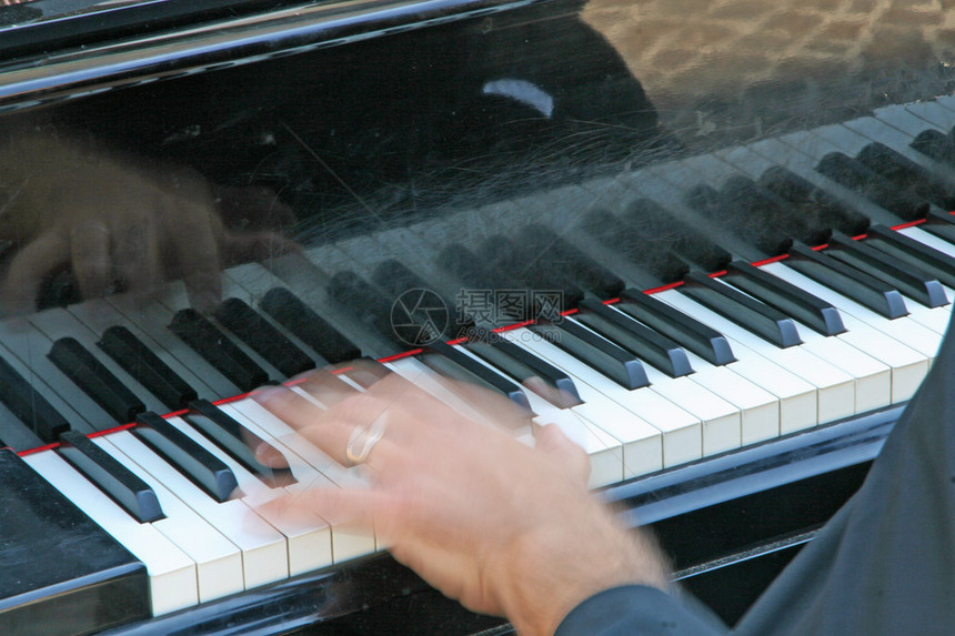 在钢琴上弹奏白键和黑键的移动手图片