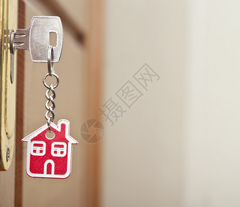 房子的象征把钥匙插在钥匙孔里背景图片