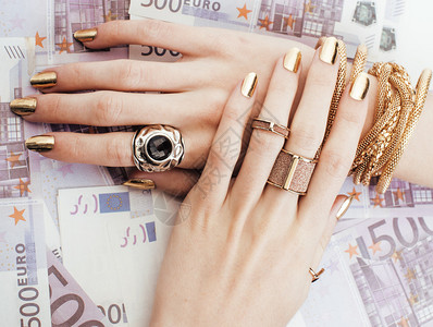 有钱女人的手有金指甲和许多珠宝戒指用现金兑换五百图片